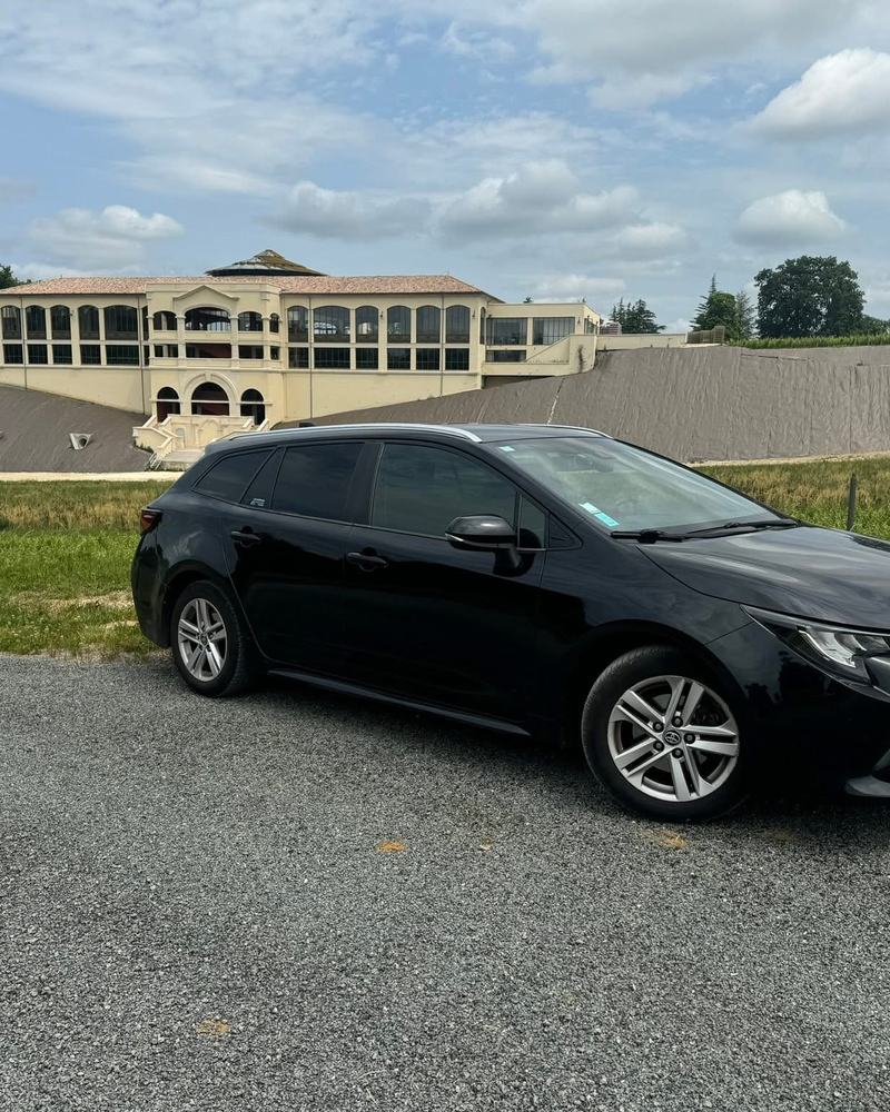 Véhicule VTC Mike'VTC33 devant un grand chai du Médoc