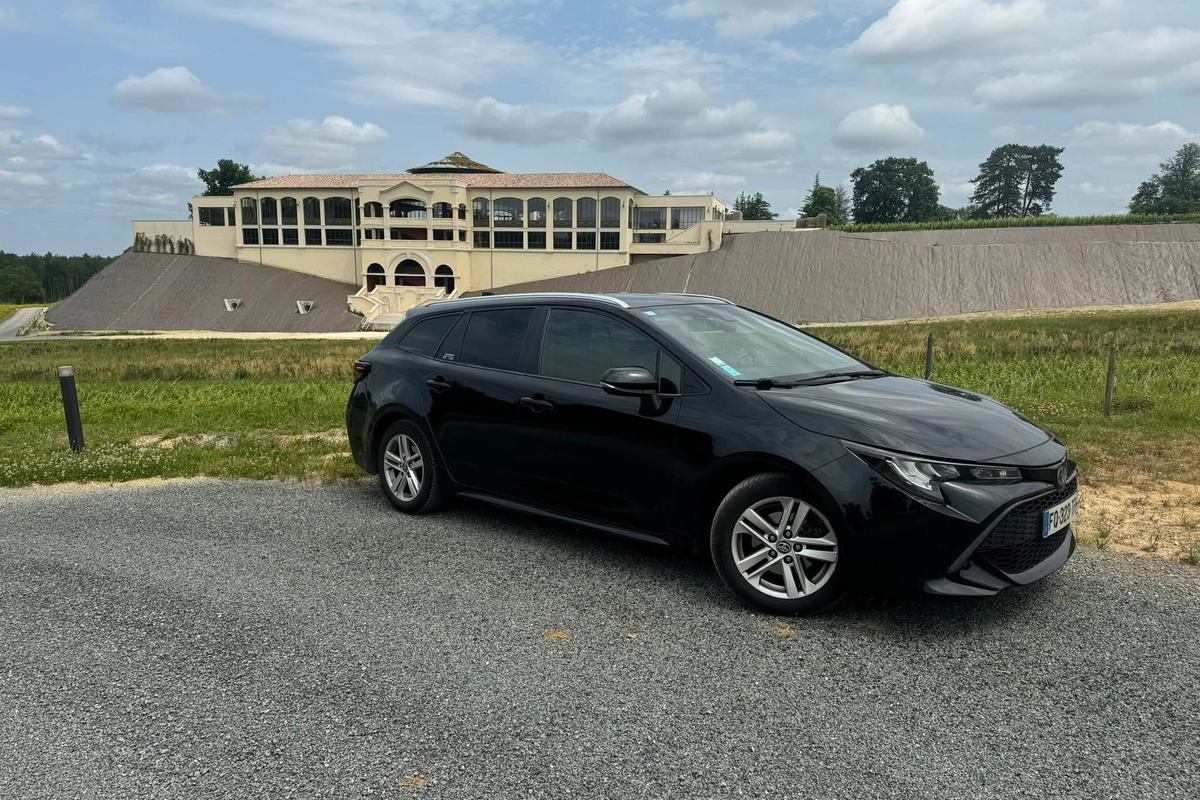 Véhicule VTC Mike'VTC33 stationné devant un grand chai du Médoc