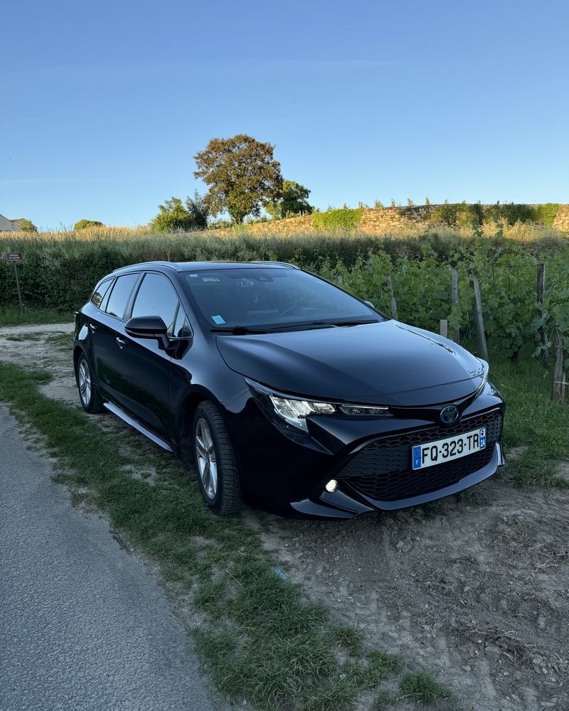 VTC noir sur un chemin entre les vignes au coucher du soleil, route des vins de Bordeaux